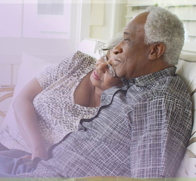Aging married senior couple sit on front porch reminiscing